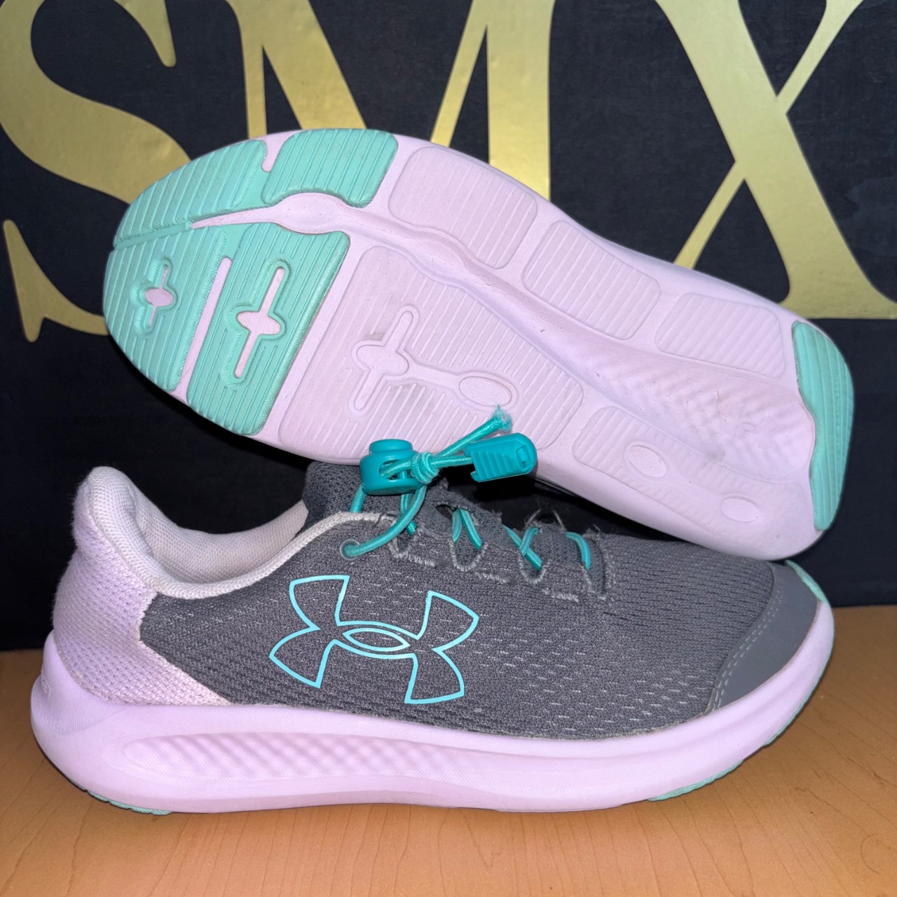 Under Armour Charged Pursuit 3 gris con detalles turquesa y blanco · Foto 1